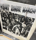 Poster with black and white photo of a crowd and text 'Hobart Zombie March' on a marble surface.