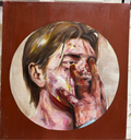 Painting of a face with a hand on a red background, displayed outdoors.